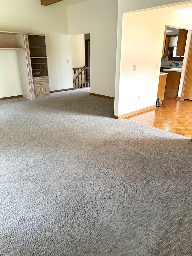 spare room with light colored carpet, a sink, and baseboards