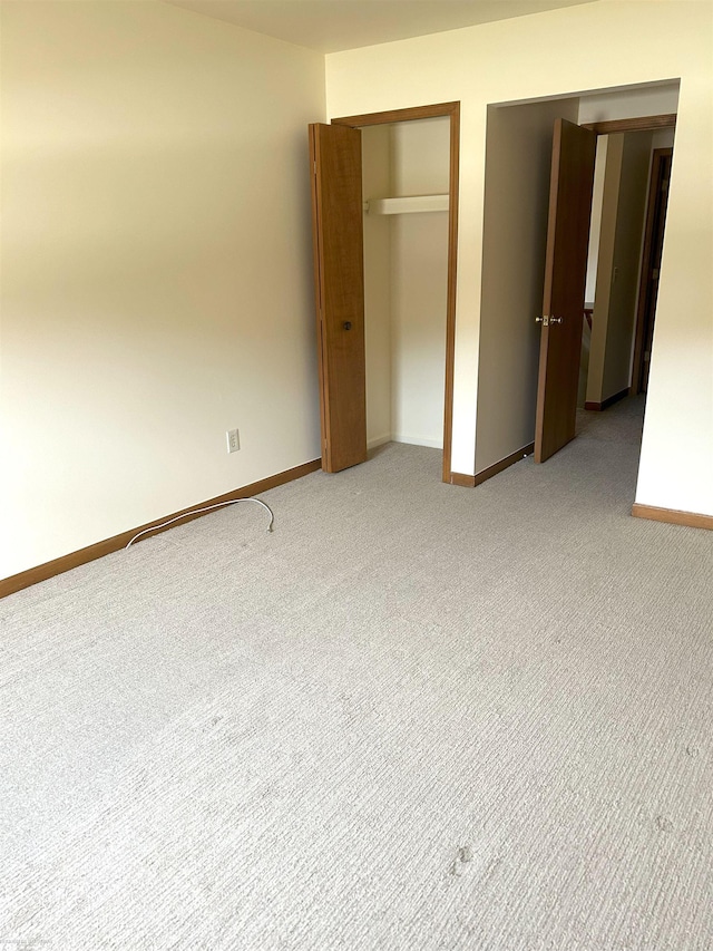 unfurnished bedroom featuring baseboards and light colored carpet