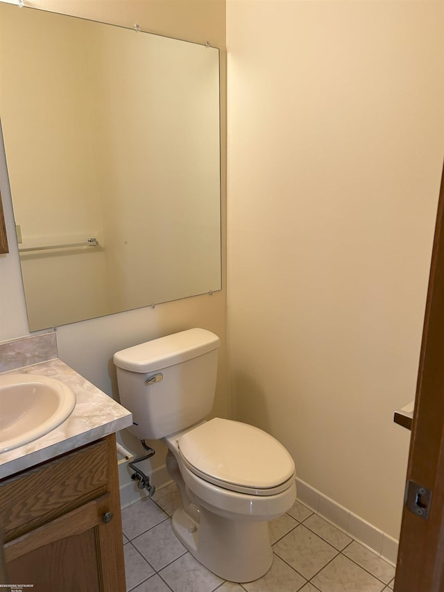 half bath featuring toilet, baseboards, tile patterned flooring, and vanity