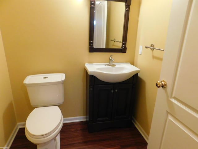 bathroom with vanity, baseboards, toilet, and wood finished floors