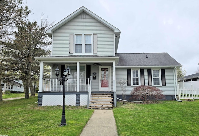 303 N 5th St, Saint Clair, MI 48079 - traditional-style home with a porch, a front lawn, ceiling fan, roof with shingles, and fence