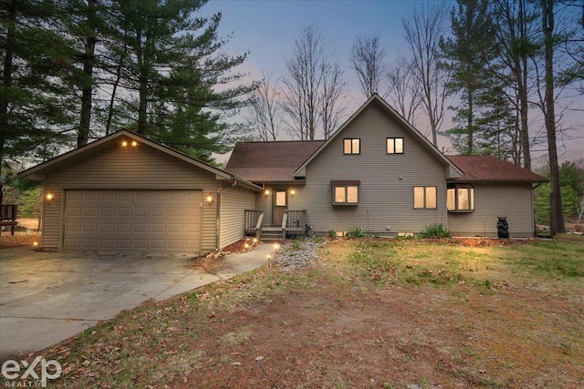 view of front facade with concrete driveway, a garage, and roof with shingles