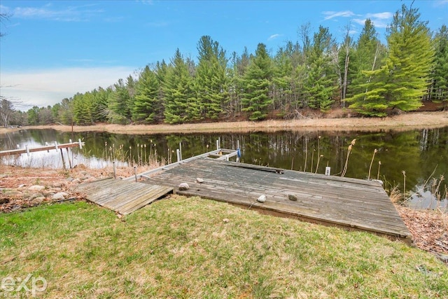 dock area featuring a forest view and a water view
