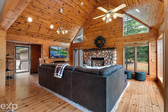 living room featuring high vaulted ceiling, wood walls, light wood-style flooring, and wood ceiling