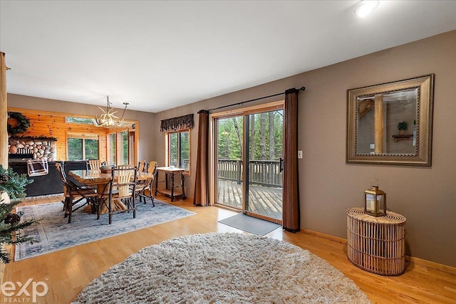 dining area featuring wood finished floors, a chandelier, and baseboards
