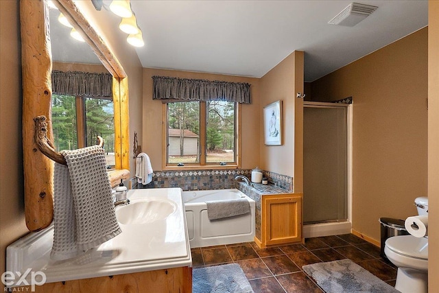 bathroom featuring toilet, visible vents, a shower stall, and plenty of natural light