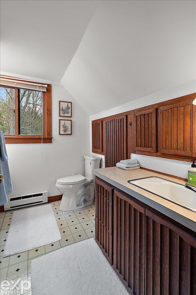 bathroom featuring a sink, toilet, lofted ceiling, and a baseboard radiator