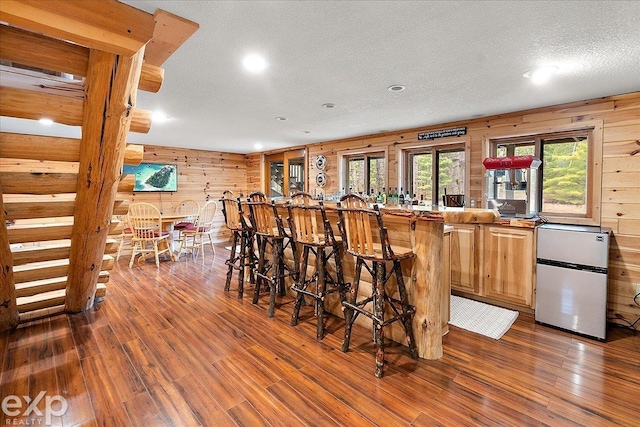 bar featuring recessed lighting, wood walls, and dark wood finished floors