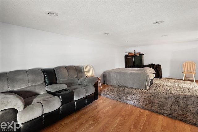 living room with recessed lighting, wood finished floors, and a textured ceiling