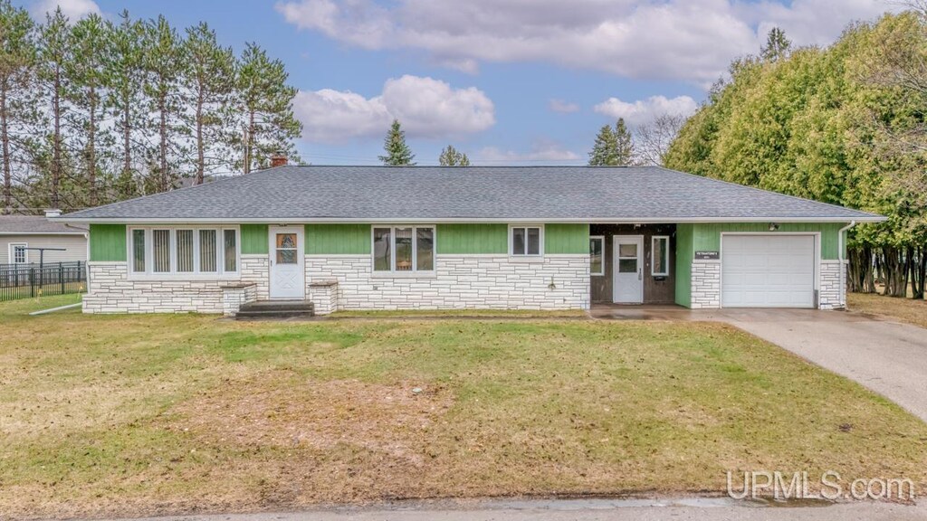 921 E Grant St, Iron Mountain, MI 49801 - single story home featuring a garage, a shingled roof, and stone siding