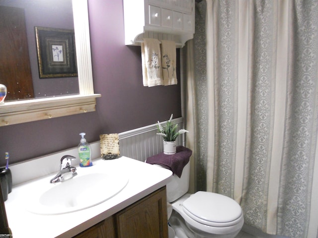 full bathroom featuring curtained shower, toilet, and vanity