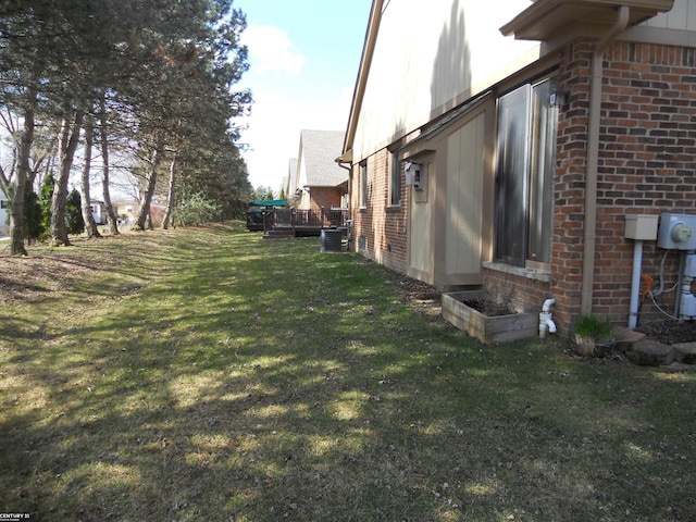 view of home's exterior featuring a lawn, central air condition unit, and brick siding