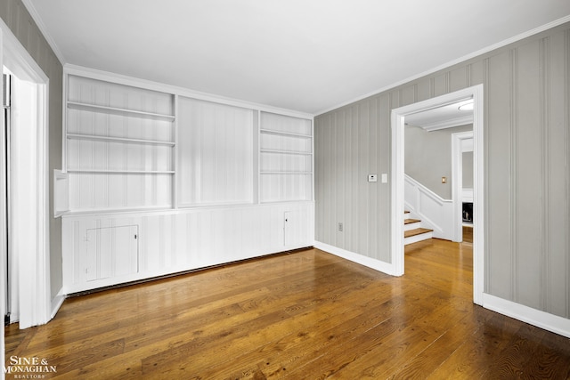 interior space with crown molding, hardwood / wood-style floors, and baseboards