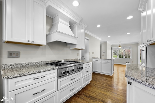 kitchen with white cabinets, dark wood-style flooring, recessed lighting, ornamental molding, and stainless steel gas cooktop