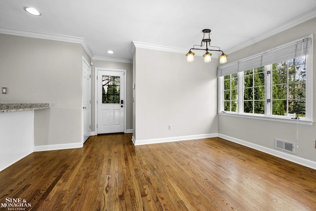 unfurnished dining area featuring recessed lighting, visible vents, baseboards, ornamental molding, and wood finished floors