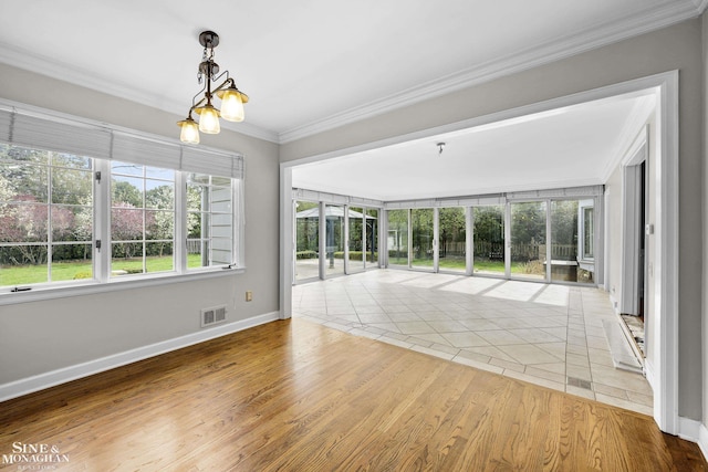 spare room with wood finished floors, visible vents, ornamental molding, and baseboards