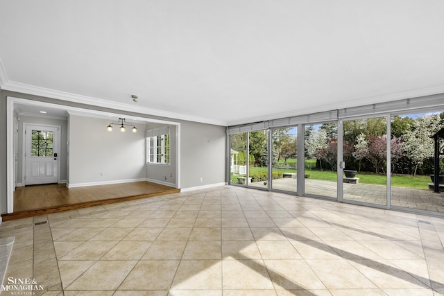 tiled empty room featuring ornamental molding and baseboards