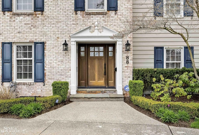 view of exterior entry featuring brick siding