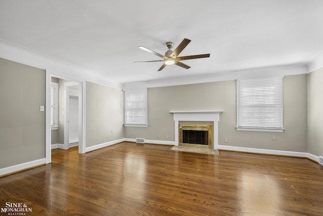 unfurnished living room with a fireplace with flush hearth, visible vents, baseboards, wood finished floors, and a ceiling fan