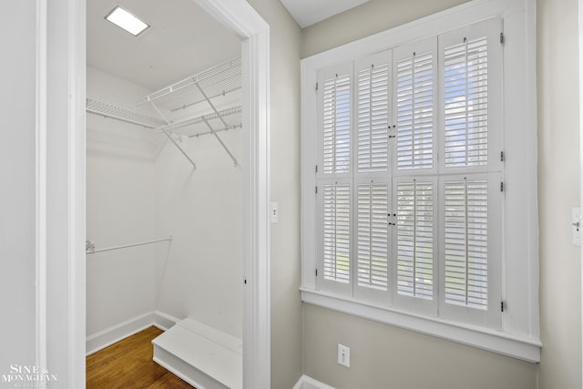 walk in closet with wood finished floors