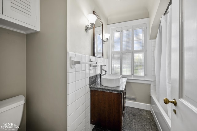 bathroom with visible vents, a wainscoted wall, toilet, tile walls, and vanity