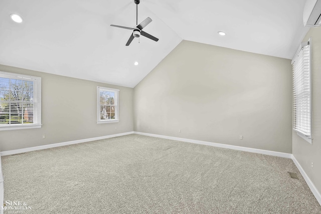 carpeted spare room featuring lofted ceiling, a wall unit AC, ceiling fan, baseboards, and recessed lighting