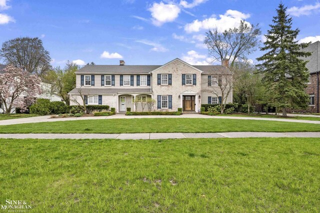 view of front of house with a front yard and a chimney