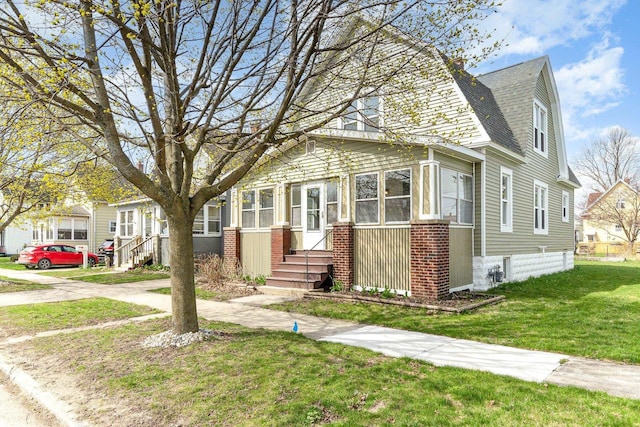 view of front of house with a front yard, a shingled roof, a gambrel roof, and entry steps