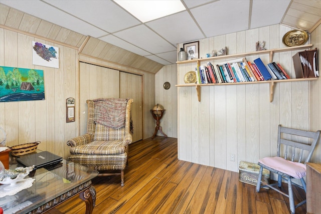 sitting room with wood walls and hardwood / wood-style floors