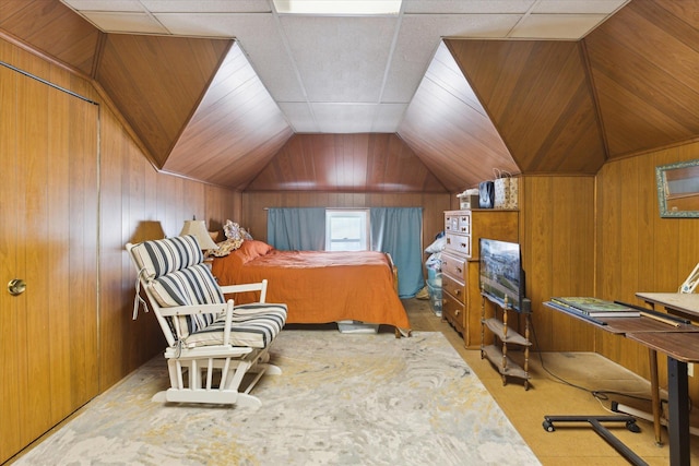 bedroom with vaulted ceiling, wood walls, and carpet