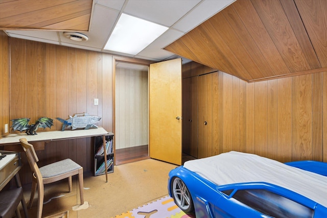 bedroom featuring wood walls and carpet floors
