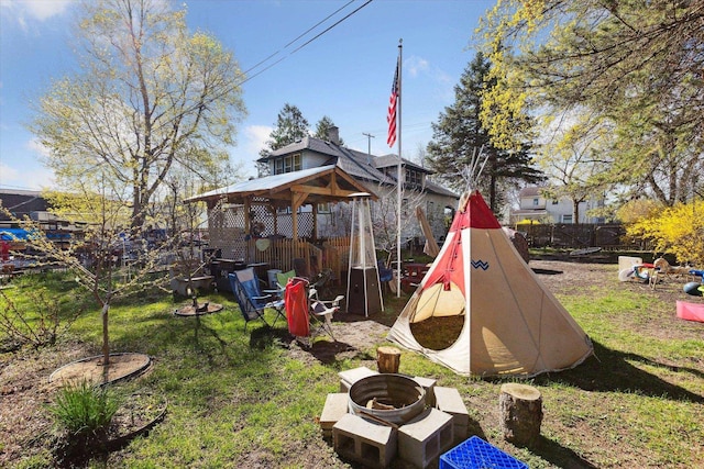 view of yard featuring a gazebo, a fire pit, and fence