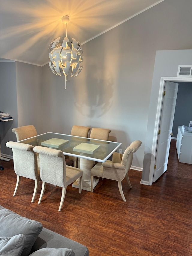 dining area with a notable chandelier, visible vents, baseboards, ornamental molding, and wood finished floors