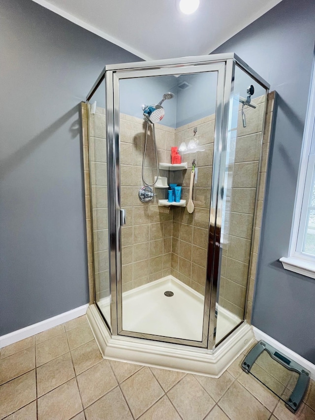 bathroom featuring baseboards, a shower stall, and tile patterned flooring
