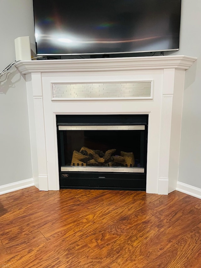 interior details with a fireplace, wood finished floors, and baseboards