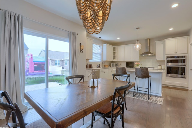 dining room featuring light wood finished floors, recessed lighting, and an inviting chandelier