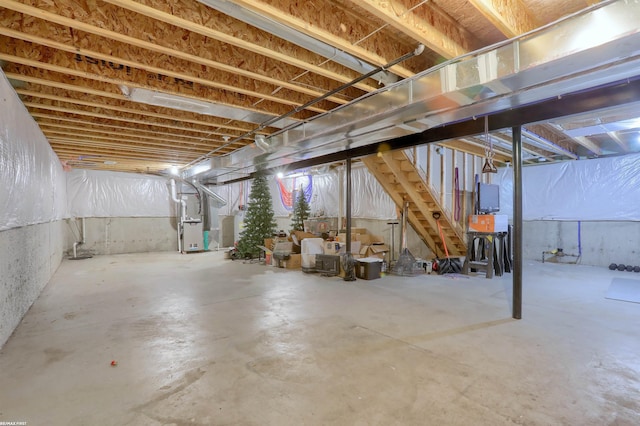 unfinished basement with stairs and heating unit