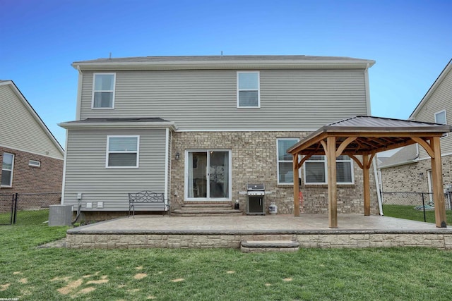 back of property with fence, a patio, a gazebo, a lawn, and central AC