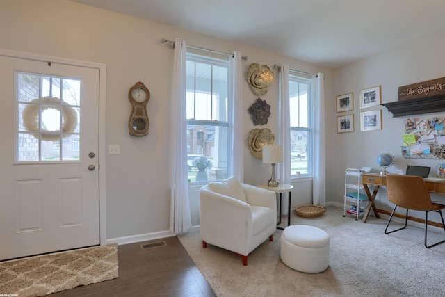 foyer featuring baseboards, visible vents, and wood finished floors