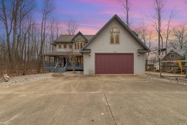 view of front of property featuring covered porch, a garage, and concrete driveway