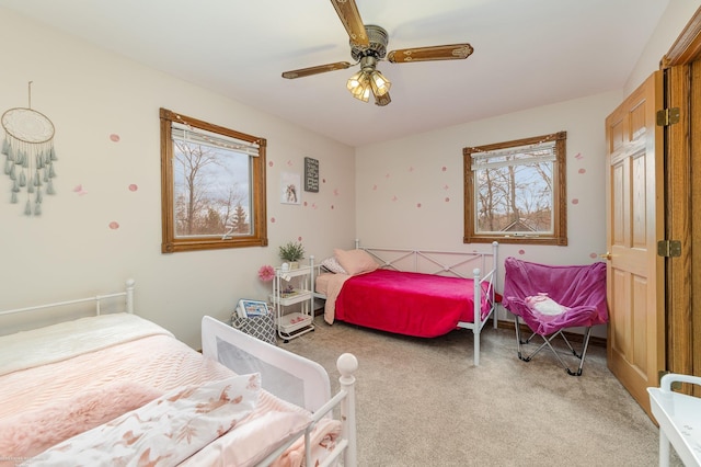 bedroom with ceiling fan and light colored carpet