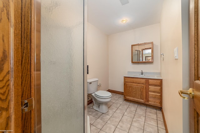 full bathroom with a shower with door, baseboards, toilet, vanity, and tile patterned flooring