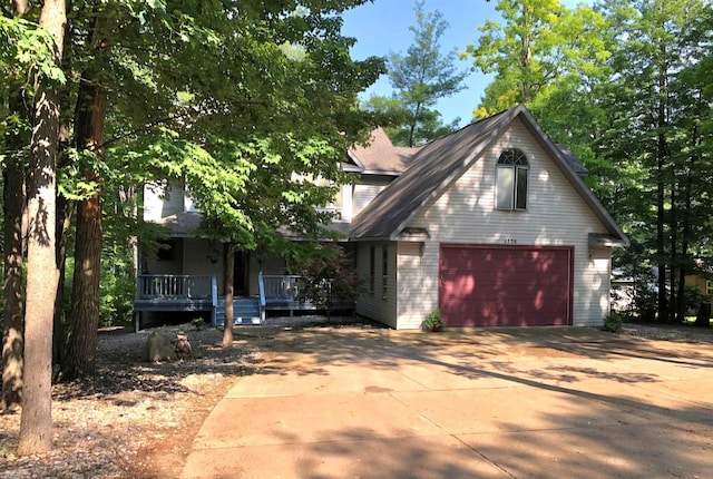 view of front of home featuring a detached garage and a porch