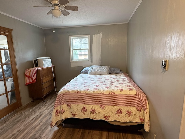 bedroom featuring wood finished floors, a ceiling fan, a textured ceiling, and ornamental molding