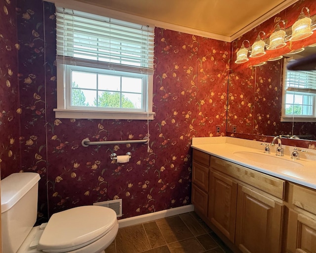 half bath with toilet, visible vents, baseboards, and plenty of natural light