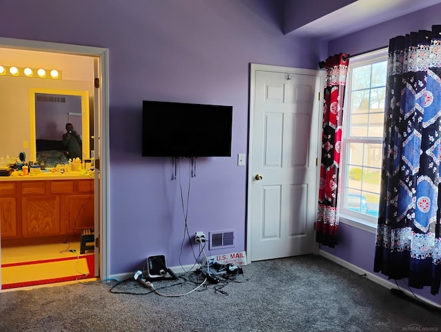 interior space with visible vents, connected bathroom, and baseboards