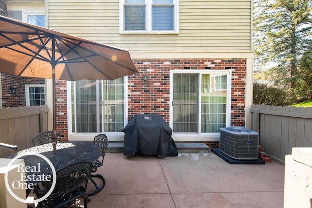 view of patio with fence, area for grilling, and cooling unit