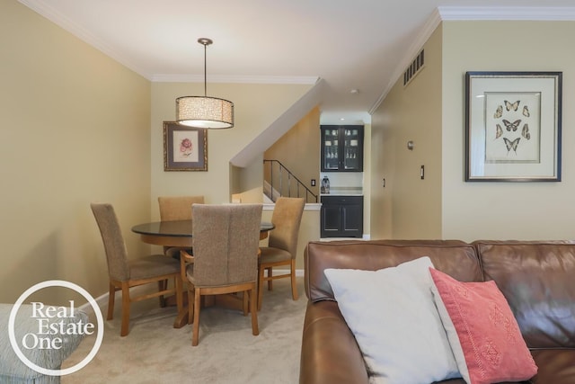 dining room with visible vents, ornamental molding, light carpet, and stairway