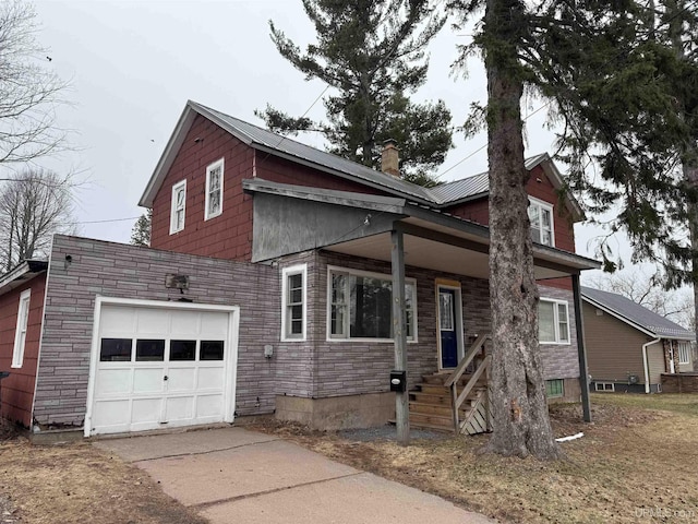 view of front of house featuring stone siding, a chimney, concrete driveway, and a garage