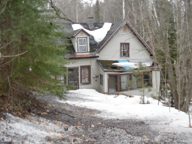 chalet / cabin with a chimney and a sunroom